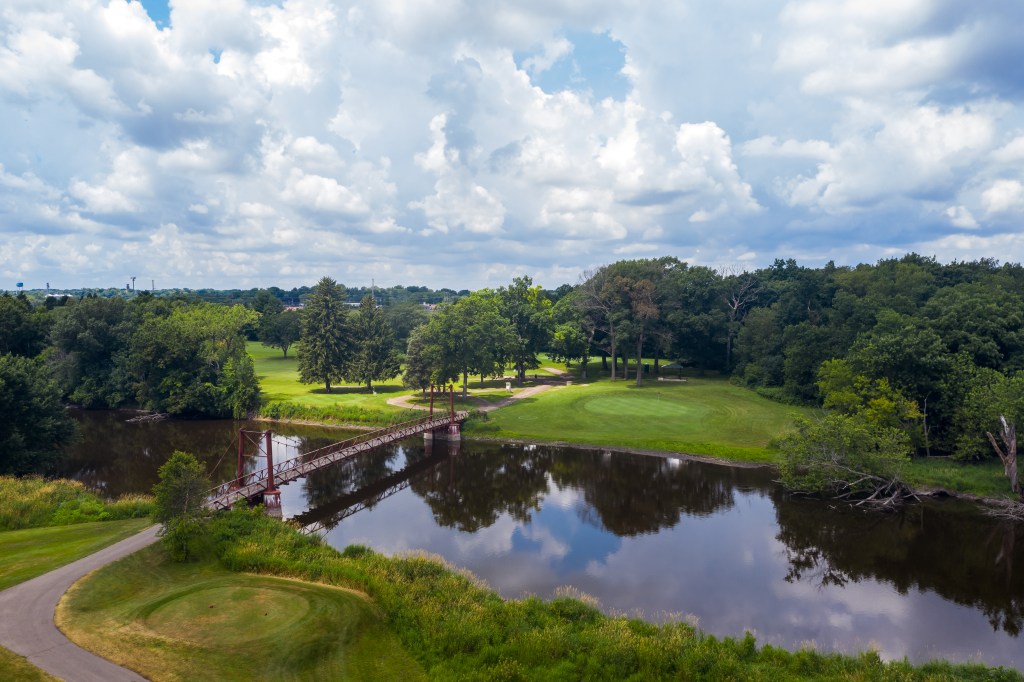 pond view of golf course with bridge