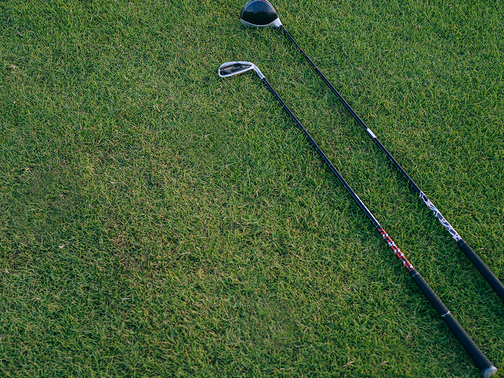 Golf clubs on golf course green